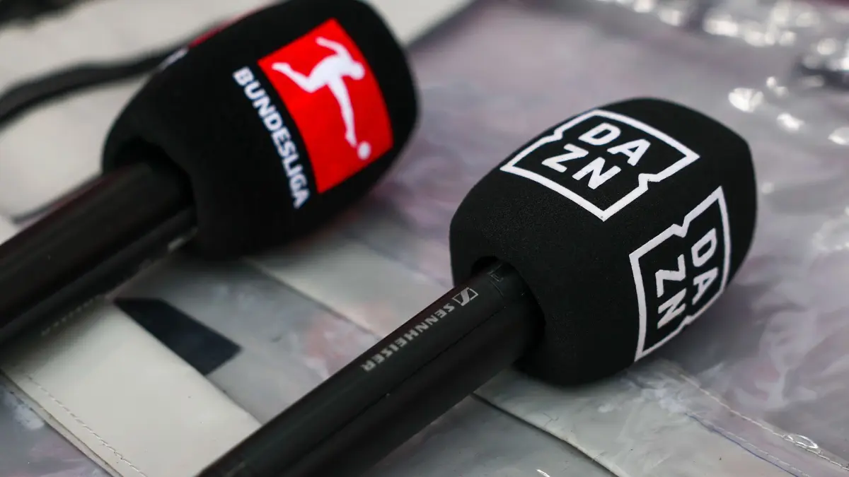 DAZN: ARCHIV - 12.01.2025, Sachsen, Leipzig: Fußball: Bundesliga, RB Leipzig - Werder Bremen, 16. Spieltag, Red Bull Arena. Mikrofone mit den Logos von Bundesliga und DAZN liegen auf einer Box. Der Streaminganbieter erstmals einen Halbjahres-Gewinn. (zu dpa: «DAZN in der zweiten Jahreshälfte erstmals profitabel») Foto: Jan Woitas/dpa +++ dpa-Bildfunk +++