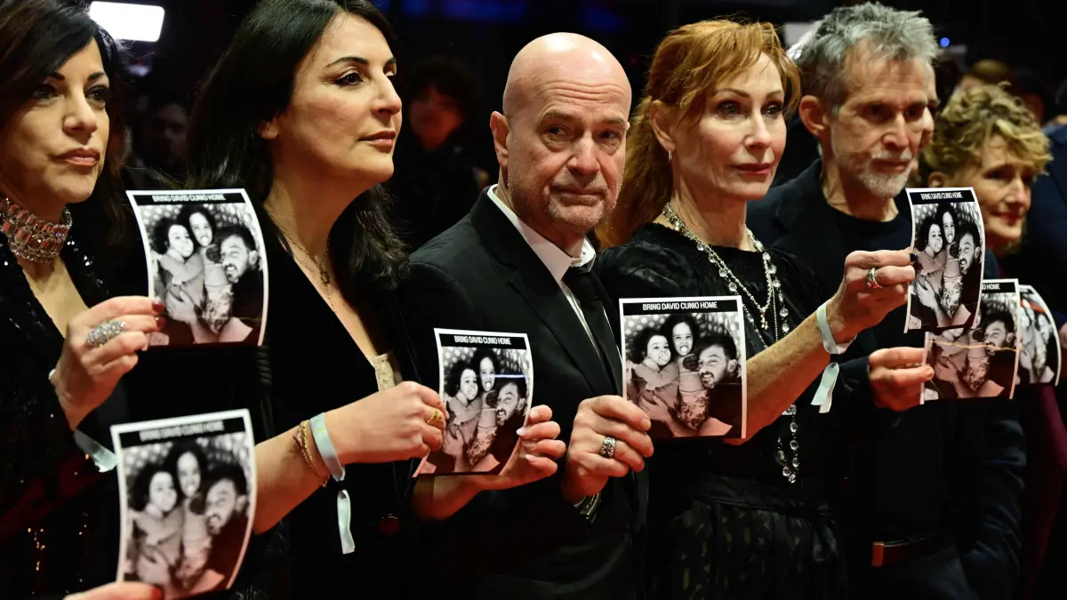 776282771: (2ndL-R) Human rights activist Duzen Tekkal, German actor Christian Berkel, German actress Andrea Sawatzki, actress, German actor Ulrich Matthes and Tricia Tuttle Berlinale director pose on the red carpet with photos of Israeli hostage David Cunio prior the opening ceremony and the screening of the film ?Das Licht? (The light) in the "Berlinale special" section of the 75th Berlinale, Europe's first major film festival of the year, in Berlin on February 13, 2025. (Photo by John MACDOUGALL / AFP)