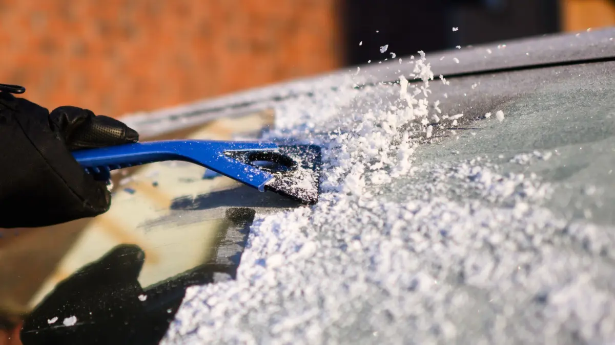 Winterwetter in Niedersachsen: 17.02.2025, Niedersachsen, Laatzen: Eine Frau kratzt bei Temperaturen deutlich unter dem Gefrierpunkt Eis von der Windschutzscheibe eines Autos in der Region Hannover. Foto: Julian Stratenschulte/dpa +++ dpa-Bildfunk +++