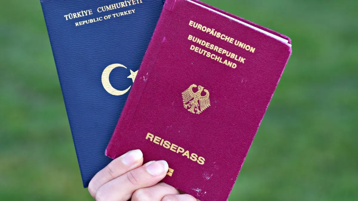 Doppelte Staatsbürgerschaft: ARCHIV - 07.06.2013, Baden-Württemberg, Mannheim: ILLUSTRATION - Eine Studentin zeigt einen türkischen Pass (l) und einen deutschen Reisepass. (zu dpa: «Türkische Gemeinde hofft auf Beibehaltung des Doppelpasses») Foto: Daniel Bockwoldt/dpa +++ dpa-Bildfunk +++