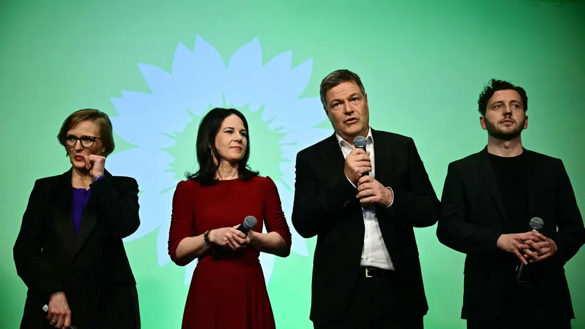 German Minister of Economics and Climate Protection and top candidate of The Greens party Robert Habeck (2R) comments on the first exit polls in the German general elections next to German Foreign Minister Annalena Baerbock (2L), and co-leaders Felix Banaszak (R) and Franziska Brantner during their electoral evening in Berlin on February 23, 2025. (Photo by Tobias SCHWARZ / AFP)