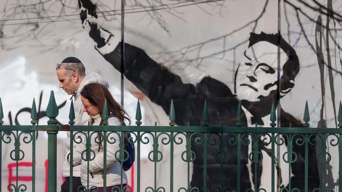 Elon Musk Graffiti in Bukarest: 03.03.2025, Rumänien, Bukarest: Menschen gehen in Bukarest an einem Wandgemälde vorbei, das Tech-Milliardär Elon Musk aus den USA mit einer Geste zeigt, die mutmaßlich an den Hitlergruß erinnert. Bei einer Feier anlässlich der erneuten Vereidigung von D. Trump als US-Präsident gestikulierte Musk am 20.01.2025 mit Gesten, die wie ein Hitlergruß anmuteten und für Furore sorgten. Foto: Andreea Alexandru/AP/dpa +++ dpa-Bildfunk +++