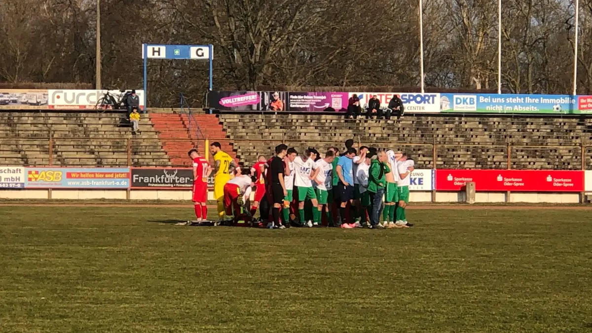Dramatische Szenen beim Spiel zwischen 1. FC Frankfurt und Grün-Weiß Lübben in der Brandenburgliga. Ein Spieler muss reanimiert werden, die Mannschaften bilden einen Sichtschutz um die Rettungsmaßnahmen.