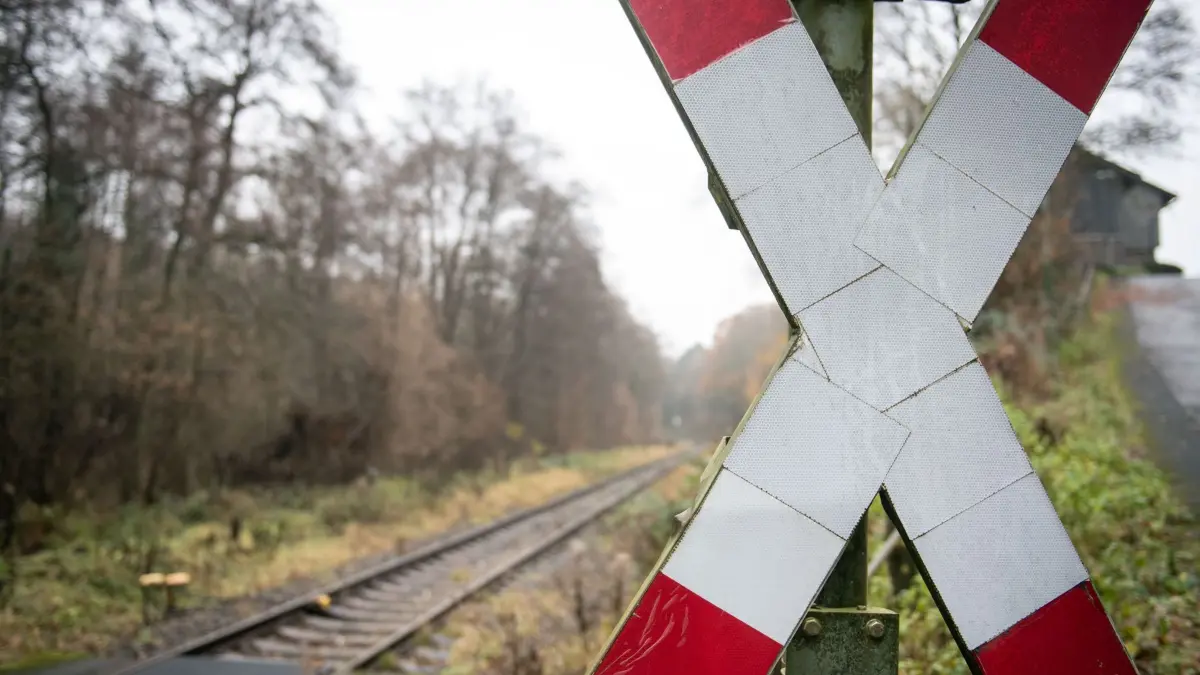 Bahnübergänge: ARCHIV - 03.12.2019, Nordrhein-Westfalen, Herdecke: Ein Andreaskreuz steht neben einem Gleis einer einspurigen Bahnverbindung. Mit einem attraktiveren Angebot im öffentlichen Personennahverkehr soll der Umstieg vom Auto auf Busse und Bahnen beschleunigt und der Klimaschutz verbessert werden. Ein entsprechendes Maßnahmenpaket für Nordrhein-Westfalen will das Landeskabinett beschließen. (zu dpa: «Obacht, Bahnübergang! - Weniger schrankenlose Querungen?») Foto: Bernd Thissen/dpa +++ dpa-Bildfunk +++