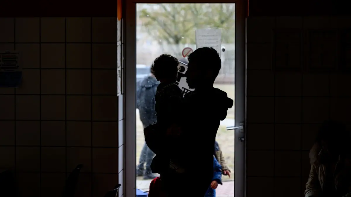 Rückführungszentrum für Asylsuchende in Eisenhüttenstadt: 13.03.2025, Brandenburg, Eisenhüttenstadt: Geflüchtete warten in einem Raum der Erstaufnahme auf dem Gelände der Zentralen Ausländerbehörde Brandenburgs (ZABH). Brandenburg geht einen neuen Weg für schnellere Rückführungen von Asylbewerbern nach Polen. Ein neues sogenanntes «Dublin-Zentrum» für eine schnellere Rückführung von Asylsuchenden in andere EU-Staaten nimmt die Arbeit auf. Dort sollen Überstellungen nach Polen beschleunigt organisiert werden. Es geht um sogenannte Dublin-Fälle, also um Menschen, die ihr Asylverfahren in einem anderen EU-Staat durchlaufen müssen. Foto: Patrick Pleul/dpa +++ dpa-Bildfunk +++