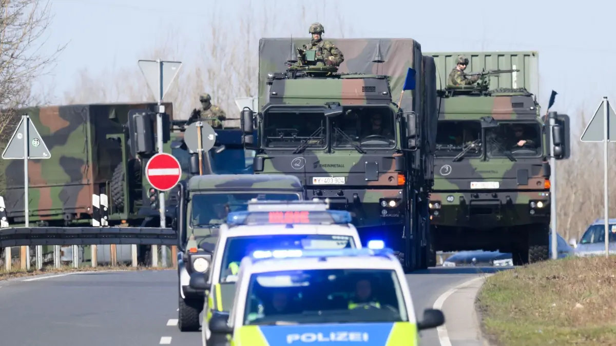 Bundeswehrübung in Hannover: 21.03.2025, Niedersachsen, Hannover: Ein Kolonne mit Fahrzeugen der Bundeswehr und schwer bewaffneten Soldaten fährt über eine Straße im Norden von Hannover. Für eine Übung der Bundeswehr fahren heute rund 320 Militärfahrzeuge durch Niedersachsen – und sorgen für Einschränkungen im Verkehr. In Hannover wollen 16 Konvois aus Hessen, Nordrhein-Westfalen und Niedersachsen einen Versorgungshalt einlegen, wie die Bundeswehr mitteilte. Foto: Julian Stratenschulte/dpa +++ dpa-Bildfunk +++