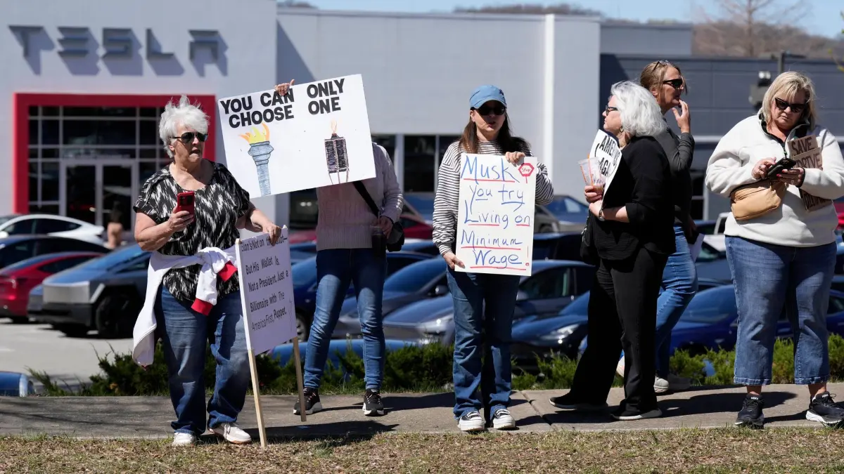 Anti-Tesla- und Anti-Elon Musk-Demonstration in Tennessee: 22.03.2025, USA, Franklin: Demonstranten tragen Schilder und skandieren Slogans gegen Elon Musk und Präsident Donald Trump vor einem Tesla-Händler. Foto: George Walker IV/AP/dpa +++ dpa-Bildfunk +++