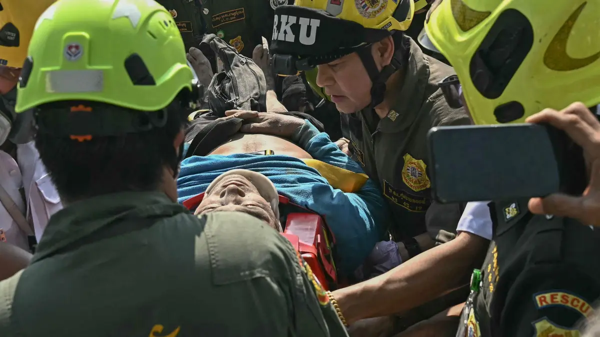 An injured man is rescued at a construction site where a building collapsed in Bangkok on March 28, 2025, after an earthquake. A powerful earthquake rocked central Myanmar on March 28, buckling roads in capital Naypyidaw, damaging buildings and forcing people to flee into the streets in neighbouring Thailand. (Photo by Lillian SUWANRUMPHA / AFP)