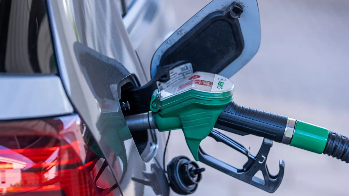 ARCHIV - 27.07.2021, Mecklenburg-Vorpommern, Schwerin: Die Zapfpistole für Super-Kraftstoff steckt in einer Tankstelle im Tankstutzen eines Autos. (zu dpa: "Koalition will CO2-Preis beim Tanken und Heizen anheben") Foto: Jens Büttner/dpa-Zentralbild/dpa +++ dpa-Bildfunk +++