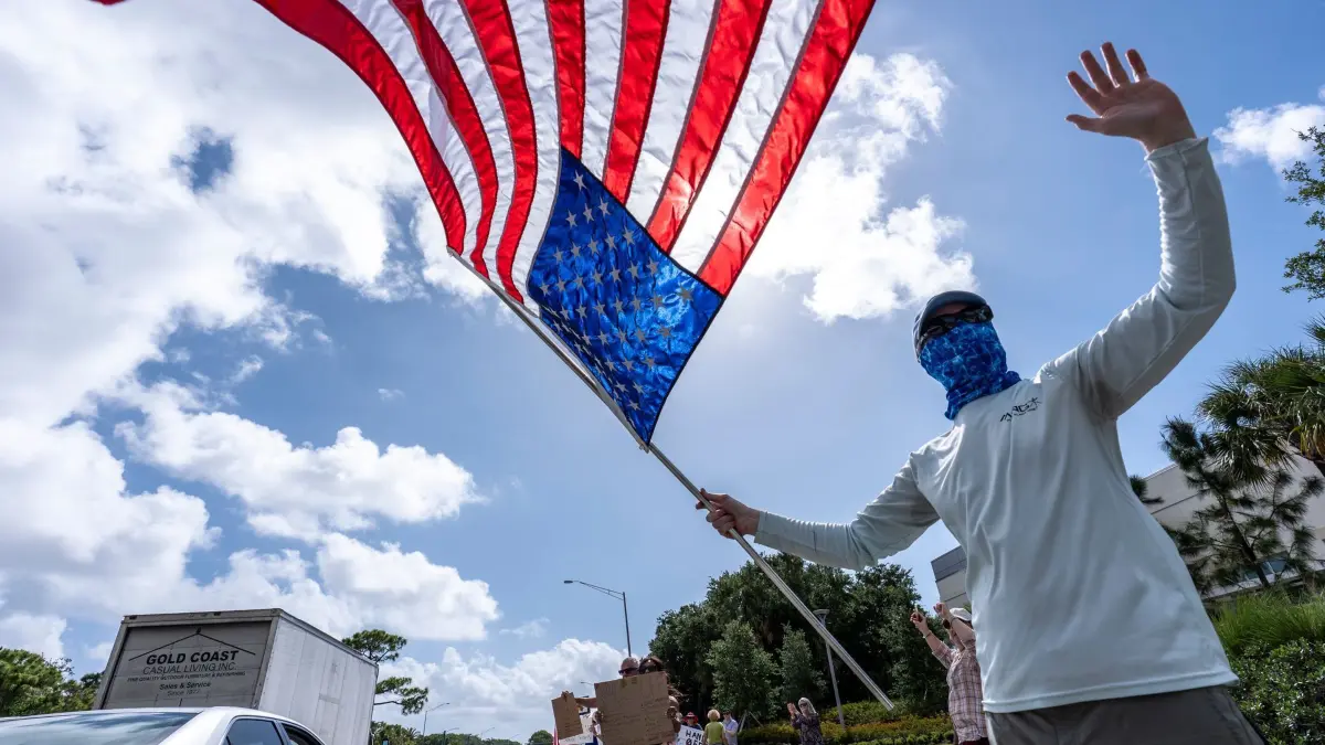 Demonstrationen in den USA gegen US-Präsident Trump: 05.04.2025, USA, Palm Beach Gardens: Aktivisten protestieren während einer "Hände weg!"-Demonstration gegen US-Präsident Trump, der sich nur wenige Kilometer entfernt in seinem Trump National Golf Club aufhält. Foto: Alex Brandon/AP/dpa +++ dpa-Bildfunk +++
