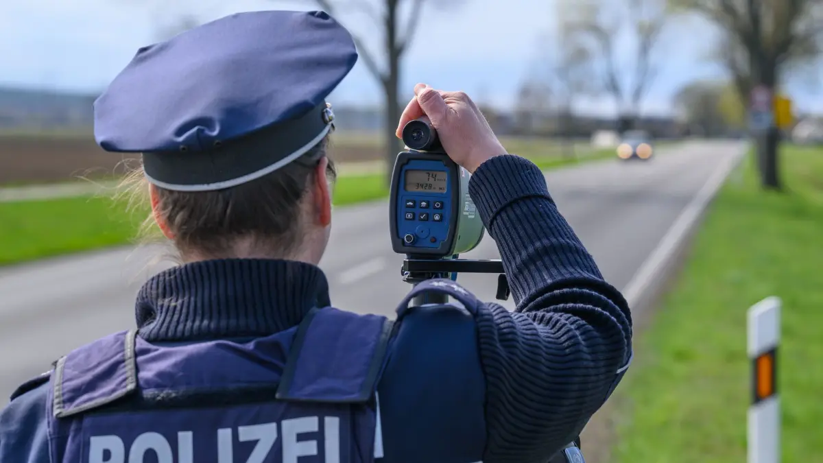 Blitzermarathon - Brandenburg: 09.04.2025, Brandenburg, Rathstock: Eine Polizeibeamtin steht mit einem Lasermessgerät an einer Bundesstraße und überwacht die Geschwindigkeit der Fahrzeuge. Am heutigen Tag will die Polizei 24 Stunden lang verstärkt Raser aus dem Verkehr ziehen. Es würden vermehrt Geschwindigkeitskontrollen in ganz Brandenburg durchgeführt werden, sagte eine Sprecherin der Polizei. Die Mittwochsaktion ist Teil der sogenannten «Speedweek» - einem einwöchigen Blitzermarathon. Der Schwerpunkt der Kontrollen liege heute auf Alleen außerhalb geschlossener Ortschaften. Foto: Patrick Pleul/dpa +++ dpa-Bildfunk +++
