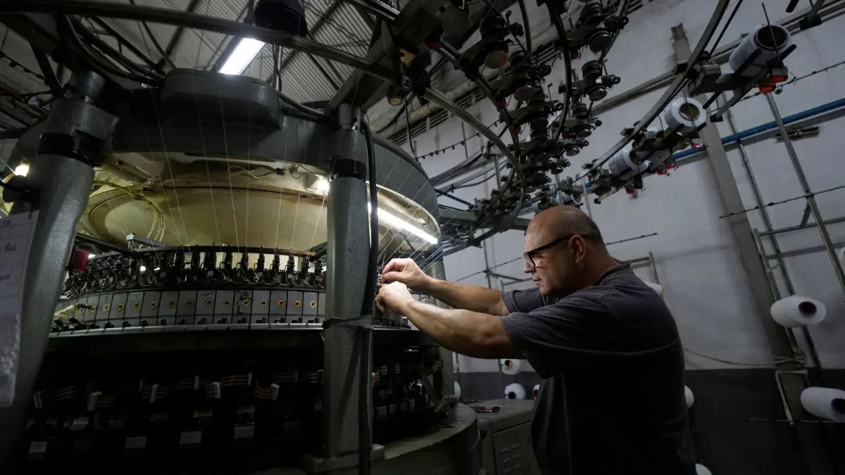 US-Zölle - Brasilien: 09.04.2025, Brasilien, Sao Paulo: Ein Mann arbeitet am Fließband eines Textilunternehmens. Foto: Andre Penner/AP/dpa +++ dpa-Bildfunk +++