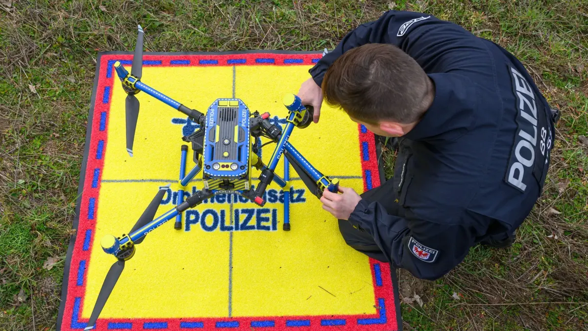 Polizei überwacht mit Drohne Lkw-Abstände auf der Autobahn: 10.04.2025, Brandenburg, Jacobsdorf: Ein Beamter der Polizei bereitet eine Drohne für den Einsatz zur Überwachung des Sicherheitsabstandes von Lkw auf der Autobahn A12 vor. Die Polizei in Brandenburg deckt Abstandsverstöße bei Lkw auf Autobahnen vermehrt mit Kamera-Drohnen auf. Am Donnerstag waren die Beamten mit einer Drohne auf der A12 in Richtung Polen nahe der Anschlussstelle Jacobsdorf im Einsatz. LKW mit einem zulässigen Gesamtgewicht von mehr als 3,5 Tonnen müssen auf Autobahnen ab einer Geschwindigkeit von mehr als 50 Stundenkilometern mindestens 50 Meter Sicherheitsabstand zum Vordermann einhalten. Die Drohne fliegt seitlich der Autobahn in etwa 100 Meter Höhe und hat dabei mit ihrer Kamera geeichte Fahrbahn-Bodenmarkierungen im Blick. Foto: Patrick Pleul/dpa - Honorarfrei nur für Bezieher des Dienstes ZB-Funkregio Ost +++ ZB-FUNKREGIO OST +++