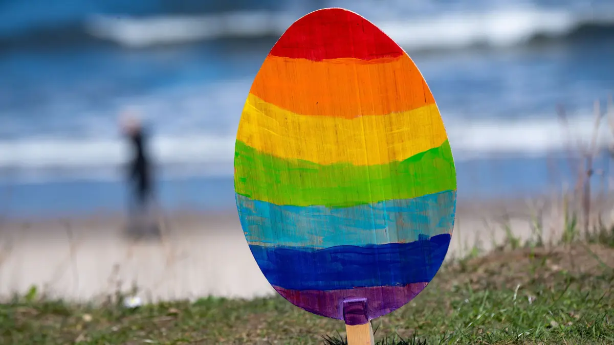 Ein Osterei steht an der Strandpromenade. Touristen sind bei sonnigem Wetter im Ostseebad Koserow am Strand unterwegs. +++ dpa-Bildfunk +++