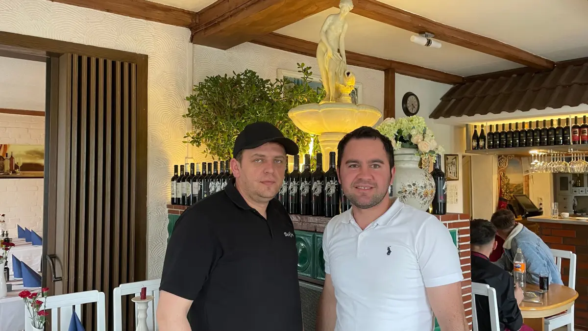Restaurantwirt Bekim Schönrowski zusammen mit Küchenchef Fejsal Redjepi vor dem Brunnen, der dem Fontana al Zampillo Ristorante den Namen gibt.