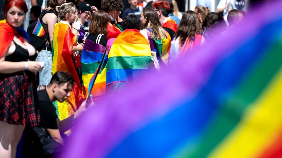 Christopher Street Day - München: ARCHIV - 10.07.2021, Bayern, München: Teilnehmer des Christopher Street Days (CSD) in der Innenstadt stehen mit Regenbogenfahnen am Stachus. (zu dpa: «Organisationen: Taten gegen queere Menschen nehmen zu») Foto: Sven Hoppe/dpa +++ dpa-Bildfunk +++