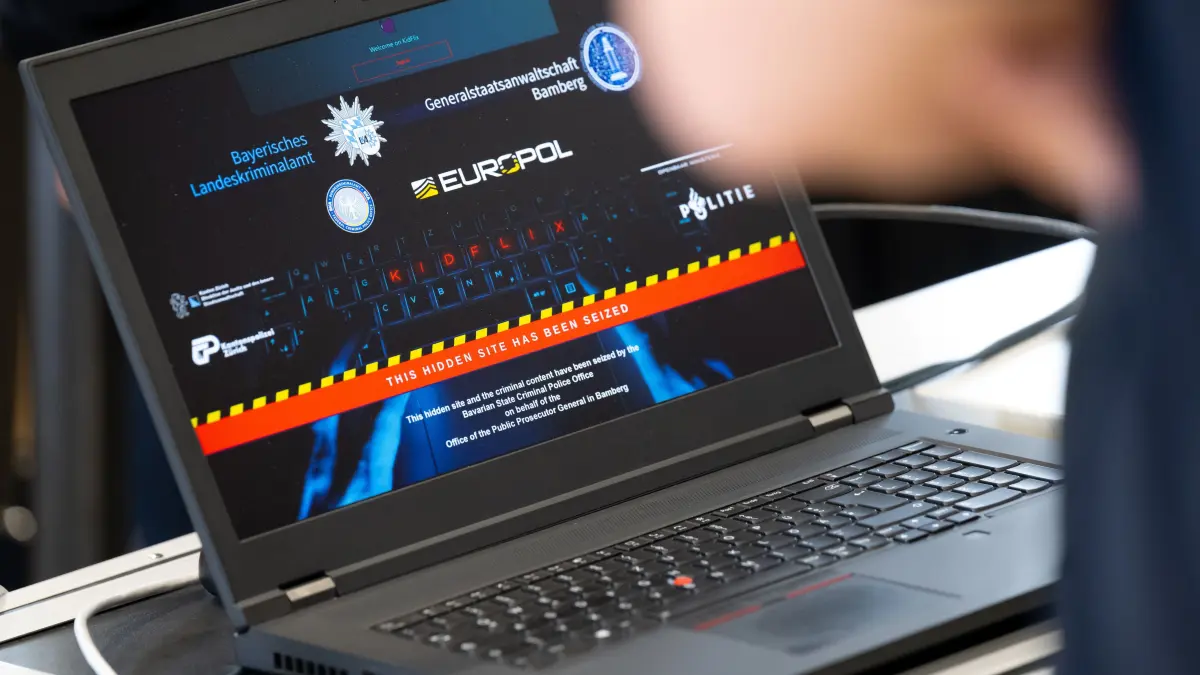 Eine symbolische Darstellung der Darknet-Plattform «Kidflix» ist im bayerischen Landeskriminalamt während einer Pressekonferenz auf einem Laptop zu sehen.