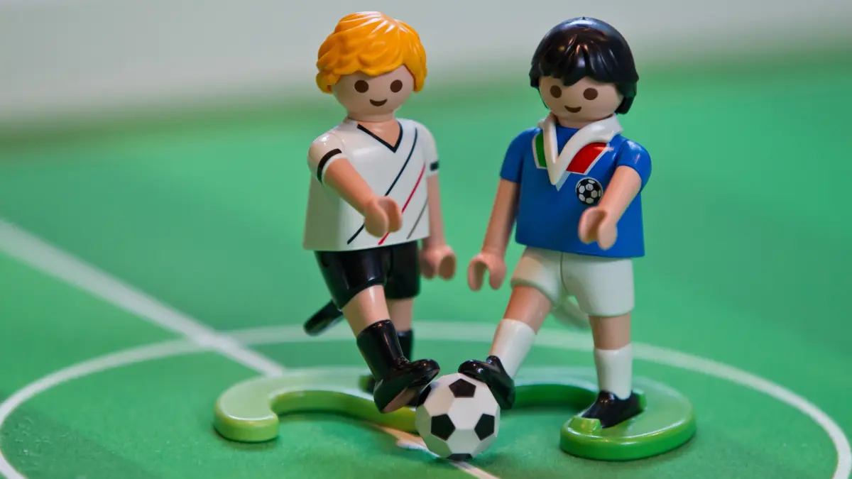 ILLUSTRATION - Fußballer-Figuren von Playmobil im deutschen und italienischen Trikot (r) stehen am Mittwoch (27.06.2012) bei dem Spielwaren-Hersteller Playmobil in Zirndorf (Mittelfranken) auf einem Fußballfeld. Die deutsche Fußball-Nationalmannschaft spielt am 28.06.2012 im Halbfinale der Fußball-Europameisterschaft gegen Italien. Die Fußball-EM in Polen und der Ukraine dauert vom 08. Juni bis zum 01. Juli 2012. Foto: Daniel Karmann dpa/lby ++ +++ dpa-Bildfunk +++