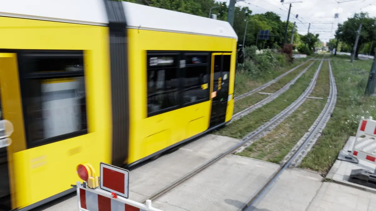 Wuhlheide-Brücke: Straßenbahnen fahren wieder: 29.05.2025, Berlin: Eine Straßenbahn fährt in den gesicherten Bereich an der gesperrten Brücke an der Wuhlheide. Die einzige Straßenbahn-Verbindung zwischen Köpenick und dem Rest der Stadt war seit Tagen dicht. Foto: Carsten Koall/dpa +++ dpa-Bildfunk +++