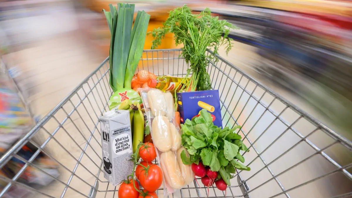 ILLUSTRATION - Ein mit Lebensmittel gefüllter Einkaufswagen wird durch einen Supermarkt geschoben (gestellte Szene, Aufnahme mit langer Verschlusszeit). (zu dpa: «Inflationsrate im März leicht gesunken») +++ dpa-Bildfunk +++