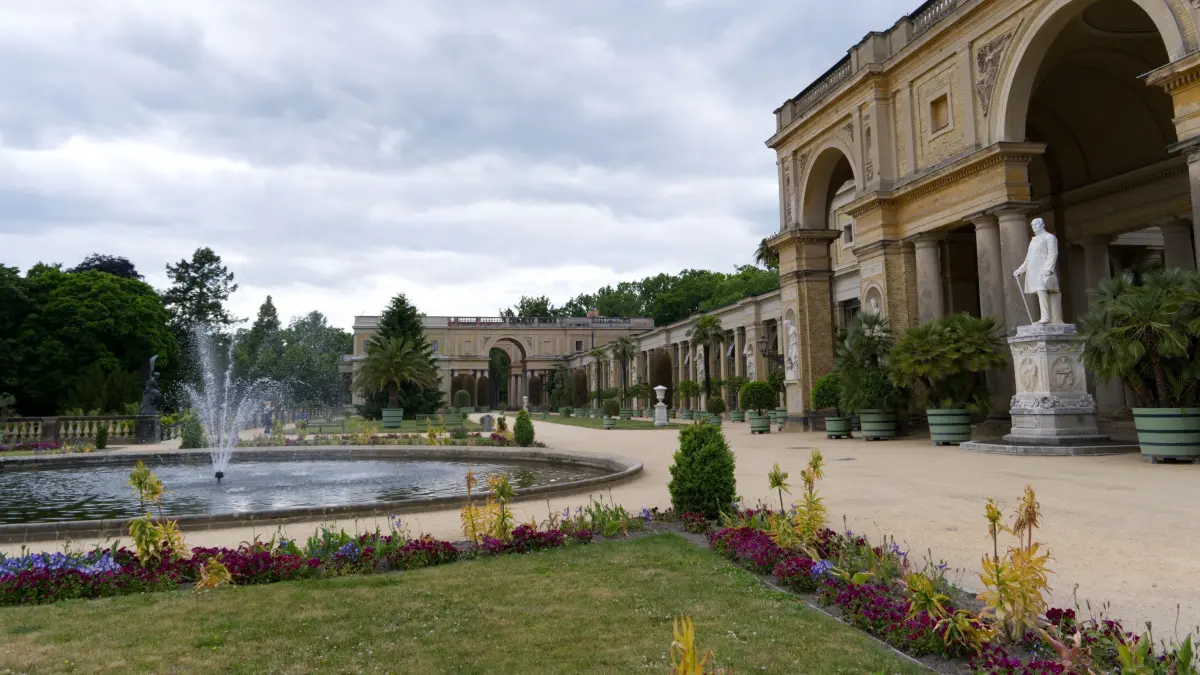 Eine schöne Gartenanlage mit Springbrunnen vor dem Orangerieschloss.