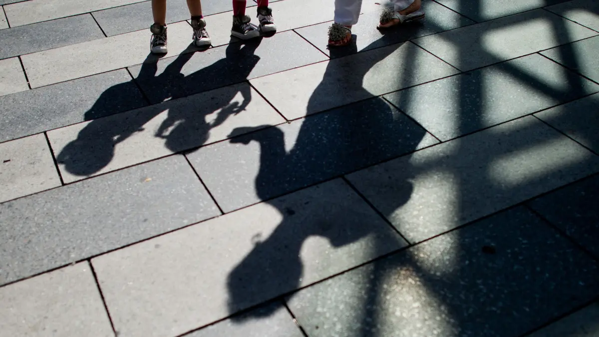 Schatten einer Frau und Kindern: GRAFIK - Gericht betont Grundsatz: Fehlverhalten der Eltern darf kein Maßstab für Sorgerechtsentzug sein. (zu dpa: «Sorgerechtsentzug: Nur zum Kindeswohl, nicht gegen Eltern») Foto: Julian Stratenschulte/dpa/dpa-tmn - Honorarfrei nur für Bezieher des dpa-Themendienstes +++ dpa-Themendienst +++