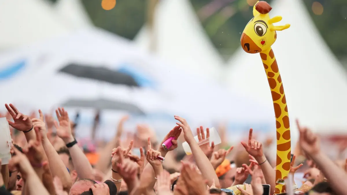 Musik-Festival „Inselfieber“ mit vielen Ballermann-Stars: 14.06.2025, Nordrhein-Westfalen, Oberhausen: Fans feiern beim Festival «Inselfieber» mit einer aufblasbaren Giraffe. Foto: Christoph Reichwein/dpa +++ dpa-Bildfunk +++