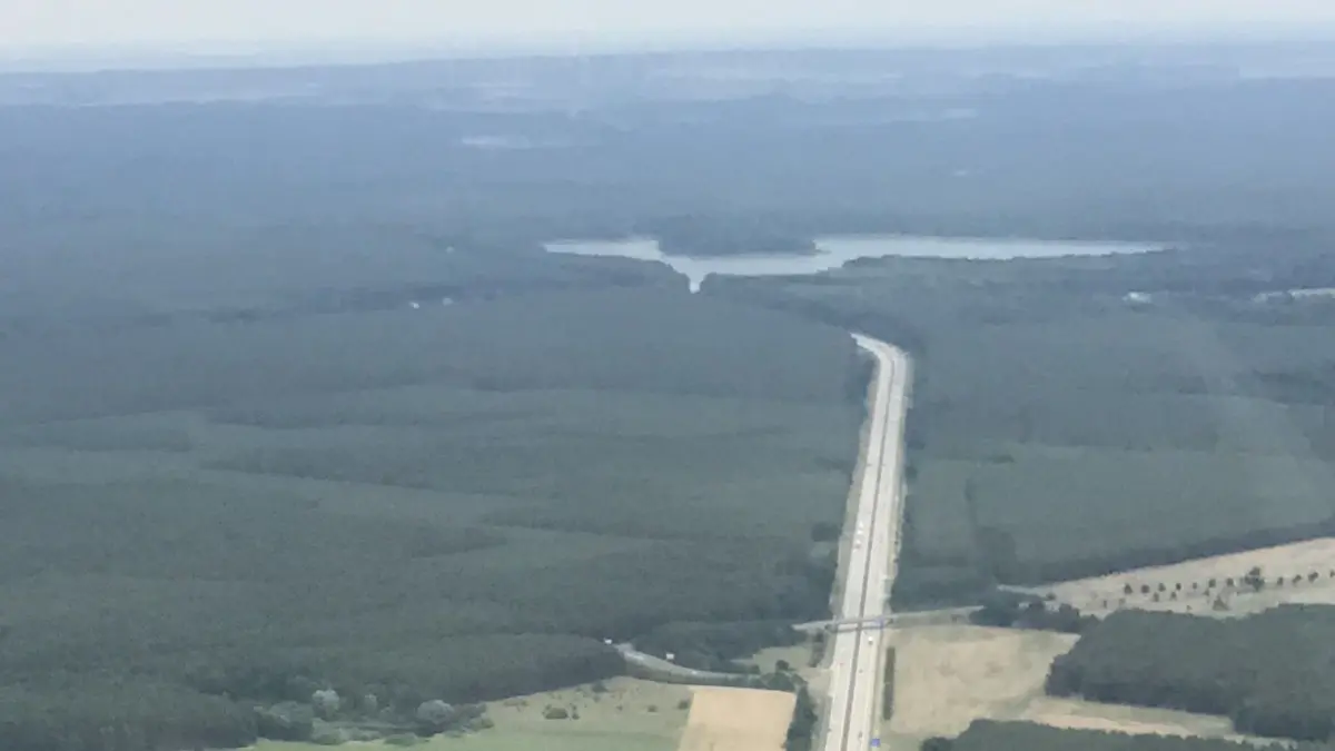 Blick aus der Luft auf die A12 in Richtung Osten: Im Vordergrund die Brücke der B 168 über die Autobahn. Links davon soll die Fläche für Gewerbe und Industrie entwickelt werden.