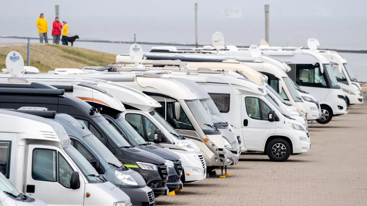Zahlreiche Wohnmobile stehen bei trübem Wetter auf einem Stellplatz an der Mole vor der Nordsee. Trotz Preissteigerungen und kurzfristiger Buchungen blicken die niedersächsischen Urlaubsregionen zufrieden auf die an diesem Wochenende endenden Herbstferien. (zu dpa: «Harz, Heide und Küste mit Buchungen in Herbstferien zufrieden») +++ dpa-Bildfunk +++