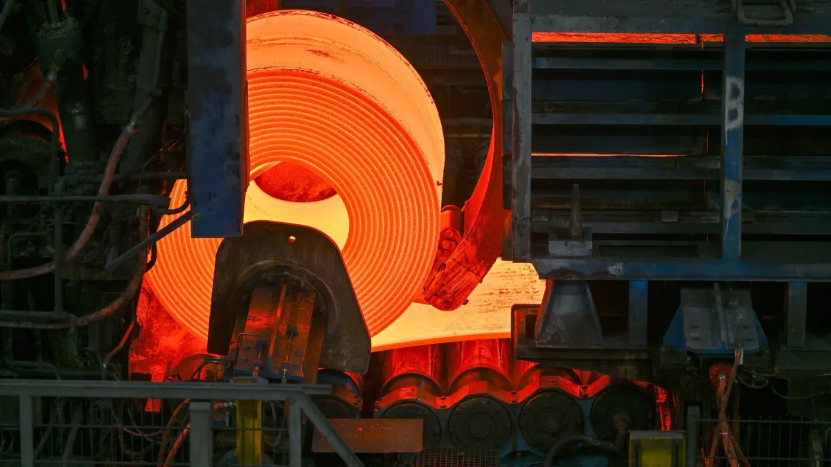 ArcelorMittal: ARCHIV - 30.05.2024, Brandenburg, Eisenhüttenstadt: Glühender Flachstahl wird zu einem Coil im Warmwalzwerk der ArcelorMittal Eisenhüttenstadt GmbH aufgewickelt. Am Nachmittag ist die Übergabe eines Förderbescheid zur klimaneutralen Stahlherstellung an das Unternehmen ArcelorMittal durch den Bundeswirtschaftsminister Habeck (Grüne) geplant. Das gemeinsame Dekarbonisierungsprojekt der Standorte Eisenhüttenstadt und Bremen ist von herausragender Bedeutung für die Zukunft der beiden Flachstahlwerke von ArcelorMittal in Deutschland. (zu dpa: ««Grüner» Stahl: Kellner fordert Regierung zum Handeln auf») Foto: Patrick Pleul/dpa +++ dpa-Bildfunk +++