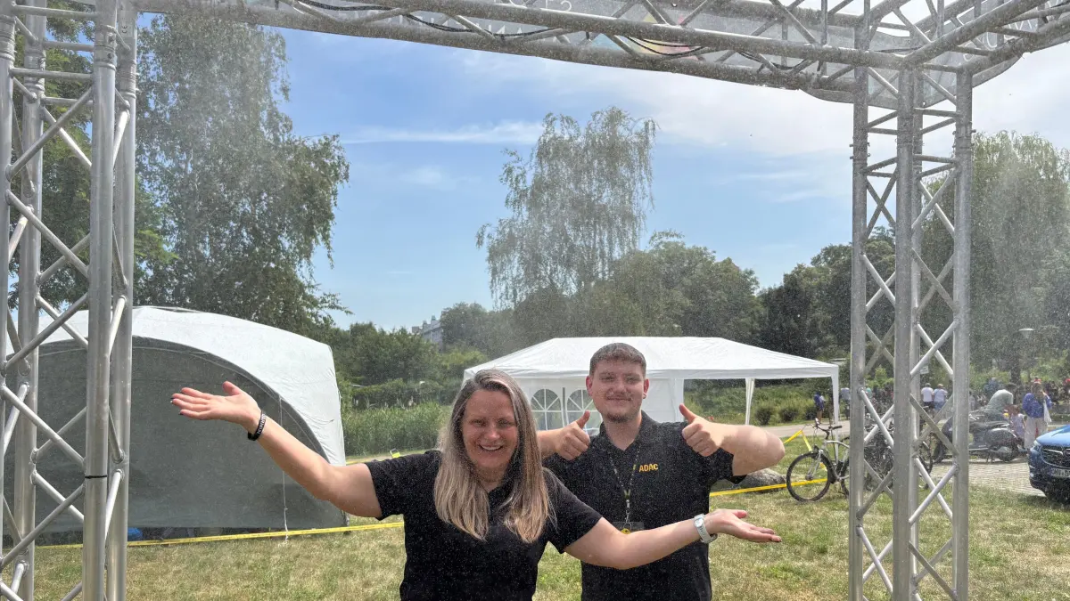 Gute Idee! Edytha Luck und Adrian Pennewitz vom ADAC-Stand nutzen ihre Pause, um sich unter der Sprühnebeldusche am Rande der Regattastrecke zu erfrischen.