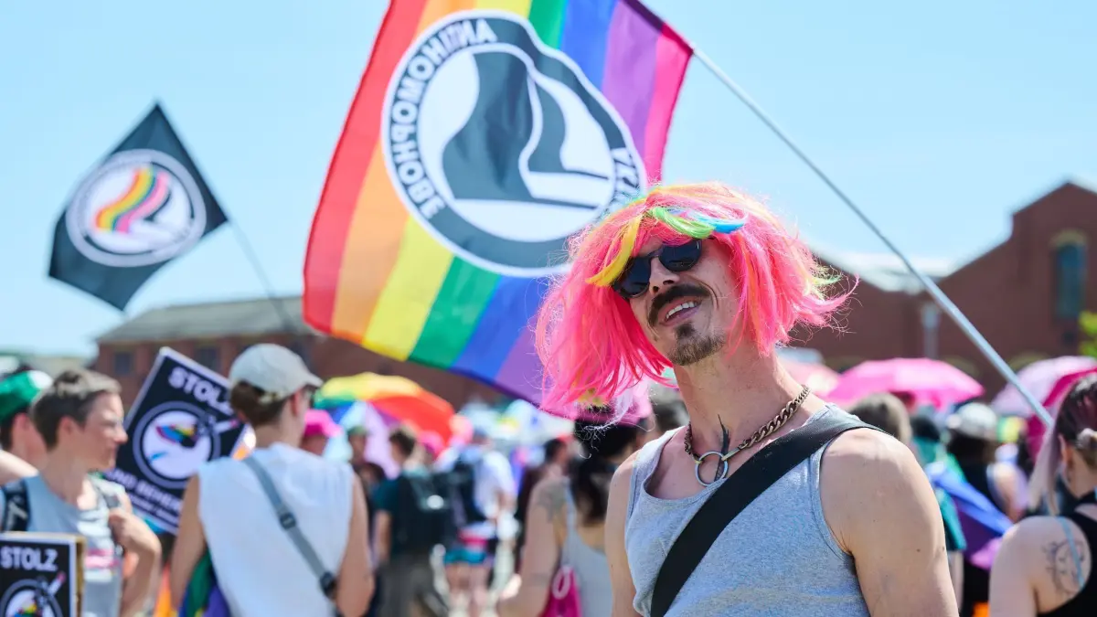 CSD in Eberswalde unter Polizeischutz: 21.06.2025, Brandenburg, Eberswalde: Ein Teilnehmer des CSD (Christopher Street Day) trägt eine bunte Perücke. Der CSD findet unter Politzeischutz nach dem Motto „Wir lassen uns nicht vertreiben“ statt. Nach dem Angriff auf ein Toleranzfest in Bad Freienwalde stehen CSD-Veranstaltungen stärker im Fokus. Foto: Annette Riedl/dpa +++ dpa-Bildfunk +++