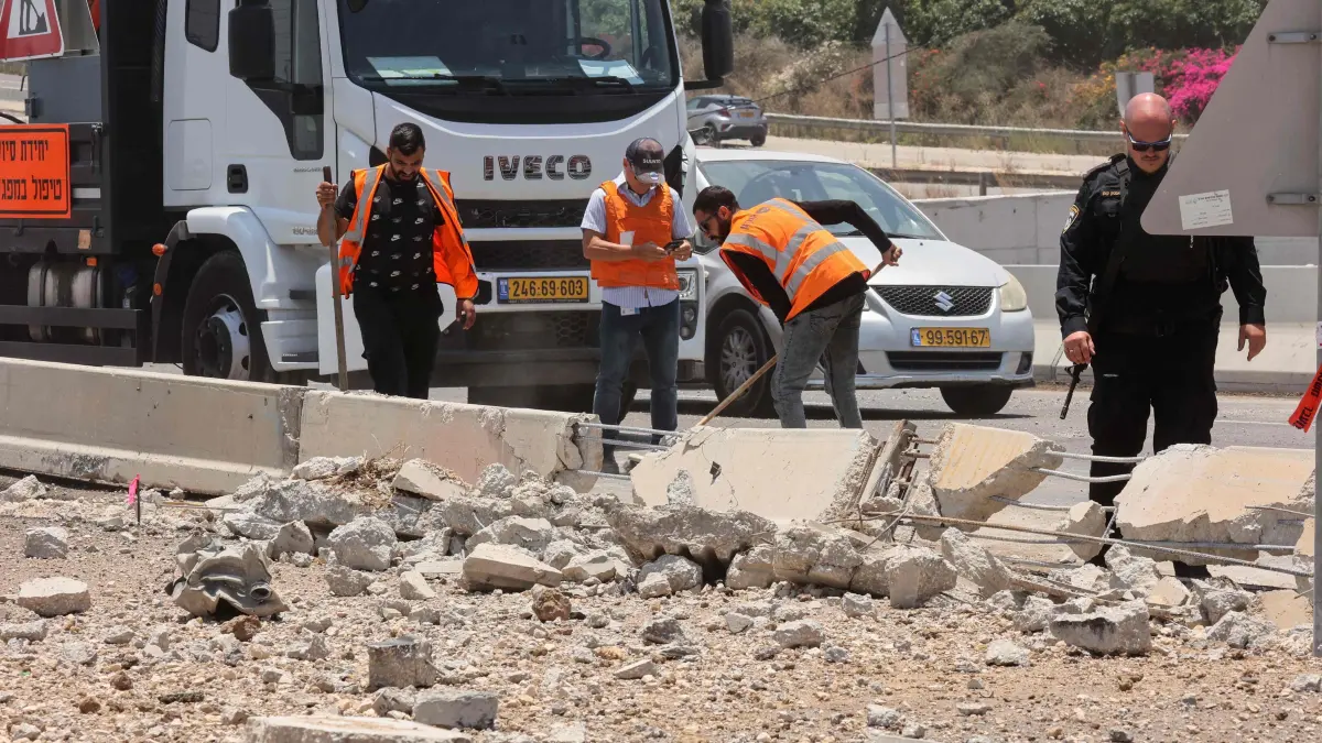 Members of Israeli security forces and emergency services clear rubble at the impact site of an Iranian rocket near the southern city of Ashdod on June 23, 2025. Sirens sounded in several areas of northern Israel on June 23, after the army reported a fresh barrage of Iranian missiles, at least the third salvo in less than two hours. (Photo by GIL COHEN-MAGEN / AFP)