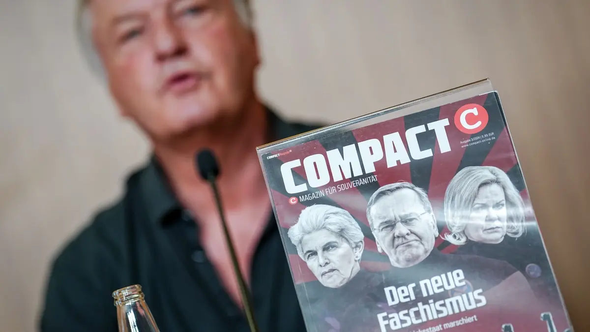 Jürgen Elsässer, „Compact“-Chefredakteur: ARCHIV - 15.08.2024, Berlin: Jürgen Elsässer, «Compact»-Chefredakteur, gibt eine Pressekonferenz zur Aufhebung des Verbots der Zeitschrift «Compact» durch das Bundesverwaltungsgericht hinter einem Titelbild seines Magazins. Das Bundesverwaltungsgericht hatte das Verbot des rechtsextremen «Compact»-Magazins im Eilverfahren vorläufig aufgehoben. Nun verhandelt es um Hauptsacheverfahren. (zu dpa: «Urteil zum Verbot des rechtsextremen Magazins «Compact»») Foto: Kay Nietfeld/dpa +++ dpa-Bildfunk +++