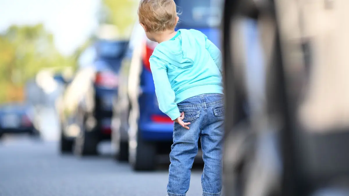 Kind steht zwischen parkenden Autos: ARCHIV - Statt Handgesten zu machen besser bremsbereit und mit angepasster Geschwindigkeit an Kindern am Straßenrand vorbeifahren. (zu dpa: «Als Autofahrer Kinder über die Straße winken – lieber nicht») Foto: Uwe Anspach/dpa-mag - Honorarfrei nur für Bezieher des Dienstes dpa-Magazin +++ dpa-Magazin +++