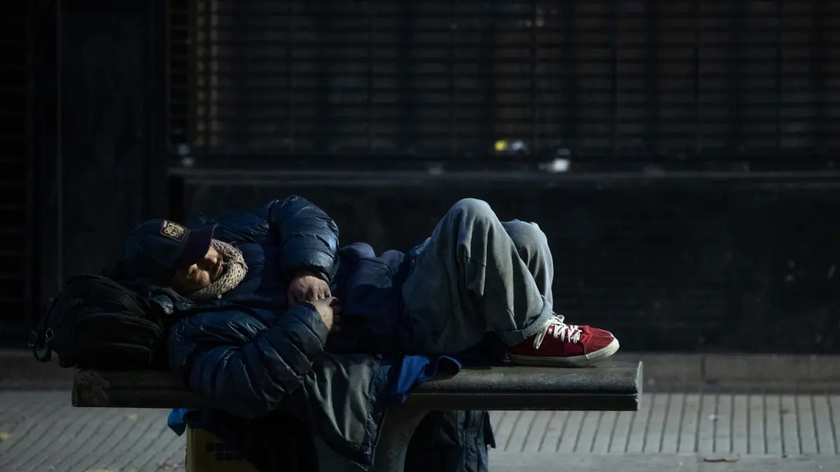 Kälte in Argentinien - Obdachlosigkeit: 03.07.2025, Argentinien, Buenos Aires: Eine obdachlose Person schläft bei eisiger Kälte auf einer Bank in der Stadtmitte. Laut der NGO Proyecto 7 sind während der aktuellen Kältewelle mindestens neun Obdachlose gestorben, zitierten lokale Medien. In der Hauptstadt Buenos Aires wurde mit minus 1,9 Grad die niedrigste Temperatur seit August 1991 gemessen. Foto: Cristina Sille/dpa +++ dpa-Bildfunk +++