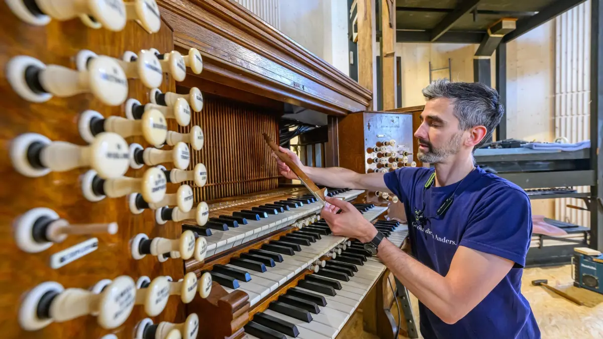Historische Orgel aus Schottland für Prenzlauer Marienkirche: 08.07.2025, Brandenburg, Prenzlau: Andreas Müller, Orgelbauer von der Eberswalder Orgelbauwerkstatt GbR, arbeitet in der Marienkirche am Spieltisch einer aus dem Jahr 1904 stammenden Orgel der Londoner Firma Hill & Son. Nach Jahrzehnten der Stille soll in der Prenzlauer Marienkirche bald wieder Orgelmusik erklingen - dank eines außergewöhnlichen Fundes in Schottland. Eine über 120 Jahre alte Orgel der Londoner Firma Hill & Son soll künftig das Herzstück der Kirche bilden. Eberswalder Orgelbauer haben sie restauriert. Jetzt wird sie in der Marienkirche aufgebaut. (zu dpa: «Marienkirche erhält Orgel aus Schottland») Foto: Patrick Pleul/dpa +++ dpa-Bildfunk +++