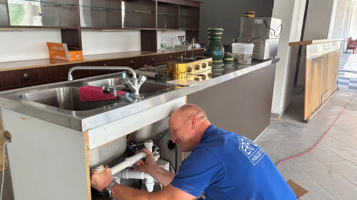 Kay Awe montiert einen Tresen und eine Spüle im ehemaligen Hotel Lunik. Damit werden die Möglichkeiten erweitert, die Räume zu nutzen.