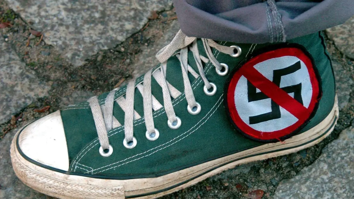 Halbe, Protest gegen Neonazis: Auf einer Demonstration im brandenburgischen Halbe trägt ein Teilnehmer einen Schuh mit dem Aufnäher eines durchgestrichenen Hakenkreuzes (Archivfoto vom 13.11.2004). Die Ostalb-Gemeinde Rosenberg macht Front gegen rechtsextreme Aktivitäten. Bürgermeister Debler (parteilos) kündigte an, mehrere hundert Bürger wollten an diesem Donnerstag (07.04.2005) gegen den Rechtsextremismus demonstrieren. Vor einigen Monaten hatte ein NPD-Aktivist einen ehemaligen Gasthof im Ort gekauft. Die Menschen in Rosenberg befürchten nun, der Erholungsort könne sich zu einem Treffpunkt von Rechtsradikalen entwickeln. Foto: Patrick Pleul dpa/lsw (zu dpa/lsw 7291 vom 05.04.2005) +++(c) dpa - Bildfunk+++