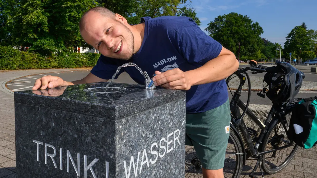 Deutschlands erster „kühler“ Radweg startet in der Lausitz: PRODUKTION - 17.07.2025, Brandenburg, Großräschen: Tobias Nowakowski, wissenschaftlicher Mitarbeiter am Lehrstuhl für Umweltökonomie an der Brandenburgischen Technischen Universität Cottbus-Senftenberg (BTU), steht mit seinem Fahrrad an einem Trinkbrunnen am neuen Radweg «Kühle Spur». Tobias Nowakowski war maßgeblich Beteiligt am Pilotprojekt Radweg «Kühle Spur», der am 19.07.2025 feierlich eröffnet werden soll. Mit dem Pilotprojekt «Kühle Spur» entstand in der Lausitz der erste Radweg Deutschlands, der an den Klimawandel angepasst ist. Er soll das Radeln auch bei Hitze angenehmer machen. Der neue Radweg «Kühle Spur» ist 30 Kilometer lang, überwiegend kühl, bietet Bademöglichkeiten und wenig Straßen - laut Ankündigung eine Neuheit für Deutschland. Entwickelt wurde das Projekt von Wissenschaftlerinnen und Wissenschaftler des Leibniz-Zentrums für Agrarlandschaftsforschung (ZALF) und der Brandenburgischen Technischen Universität Cottbus-Senftenberg (BTU). Foto: Patrick Pleul/dpa +++ dpa-Bildfunk +++