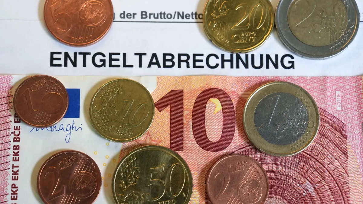 Entgeltabrechnung: ILLUSTRATION - 27.06.2025, Hamburg: ILLUSTRATION - Euro- und Centmünzen liegen auf einem 10-Euro-Schein. (zu dpa: «Weniger als 2.750 Euro Lohn für jeden Dritten in Brandenburg») Foto: Marcus Brandt/dpa +++ dpa-Bildfunk +++