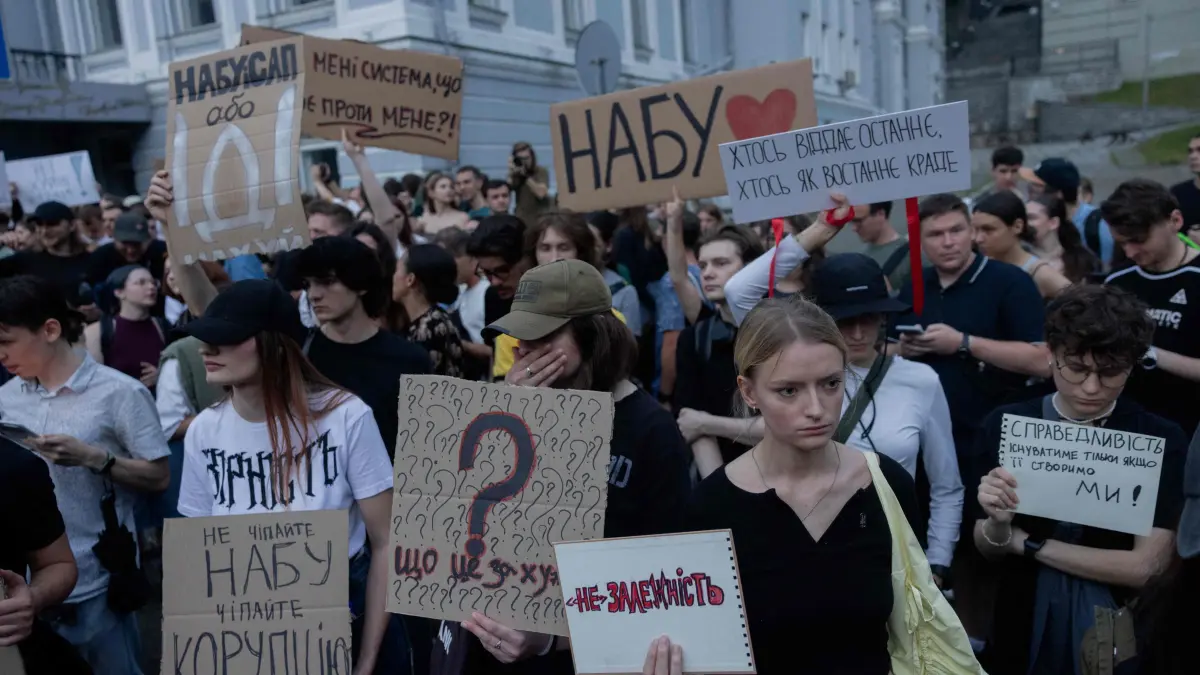Protesters hold placards during a demonstration calling for the Ukrainian president to veto a law passed by parliament that reduces the powers of Ukraine’s National Anti-Corruption Bureau (NABU) and Specialised Anti-Corruption Prosecutor's Office (SAPO) in downtown Kyiv on July 22, 2025, amid the Russian invasion of Ukraine. Ukraine's parliament voted on July 22 to revoke the autonomy of the two anti-corruption agencies, a move that critics say will allow government meddling in high-profile graft cases. (Photo by Tetiana DZHAFAROVA / AFP)