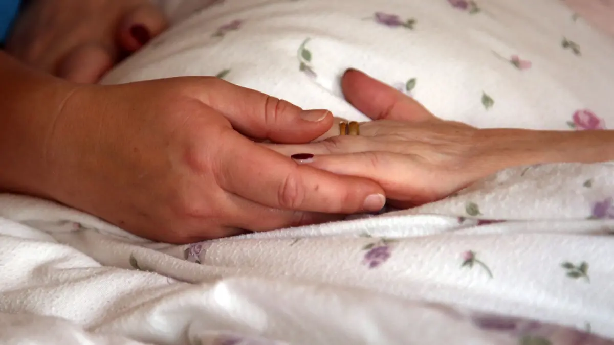Ermittlungen gegen Palliativmediziner: ARCHIV - 28.11.2018, Sachsen-Anhalt, Stendal: Die Hände einer Bewohnerin liegen in einem Hospiz auf einer Bettdecke. (zu dpa: «Slowenien erlaubt assistierten Suizid für Schwerkranke») Foto: Peter Förster/dpa-Zentralbild/dpa +++ dpa-Bildfunk +++
