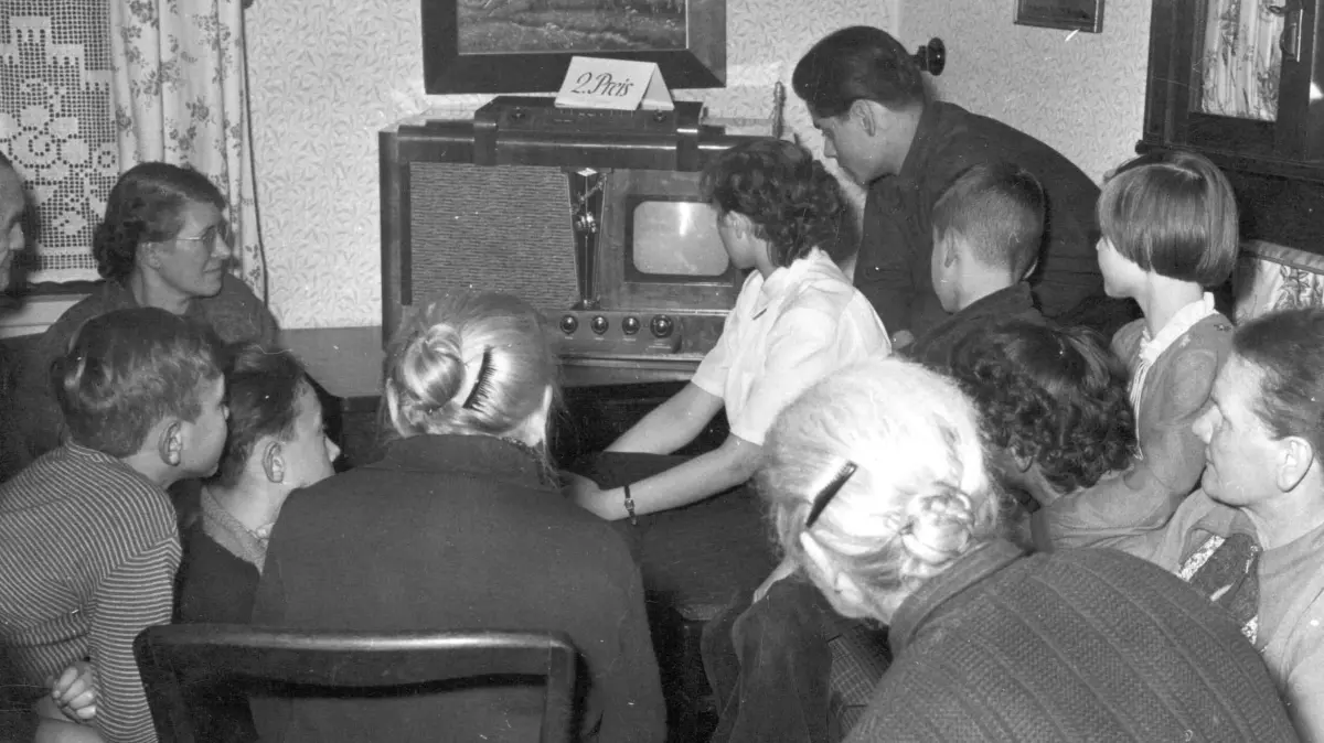 Menschen umringen in Leipzig den ersten in der ehemaligen DDR produzierten Fernseher des Typs "Leningrad" (Archivfoto aus dem Jahr 1954). Unter dem Titel «Feierabend-Fernsehzeit» startet am Samstag (24.07.2004) im Filmmuseum in Düsseldorf eine Ausstellung mit alten Geräten, Reliquien des TV-Zeitalters. Zudem stellen rund 40 Sender 150 Programm-Ausschnitte von der Nachrichtensendung bis zur Talk-Show, von Starkomödianten der TV-Urzeit, Heinz Erhard, bis zur Reality-Show «Big Brother» zur Verfügung. dpa/lnw (zu lnw: "Feierabend-Fernsehzeit: Filmmuseum zeigt ein halbes TV-Jahrhundert" vom 23.07.2004) +++ dpa-Bildfunk +++