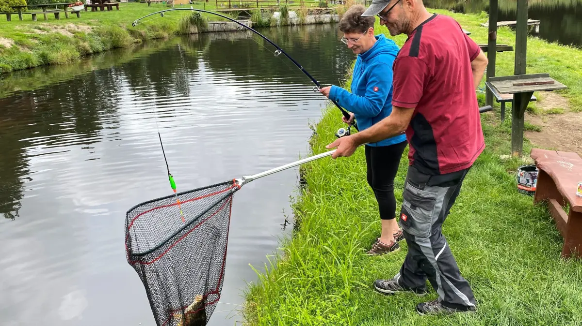 Holen einen dreipfündigen Karpfen aus dem Wasser: Heike und Sven Fischer an den Angelteichen in Chlebowo.