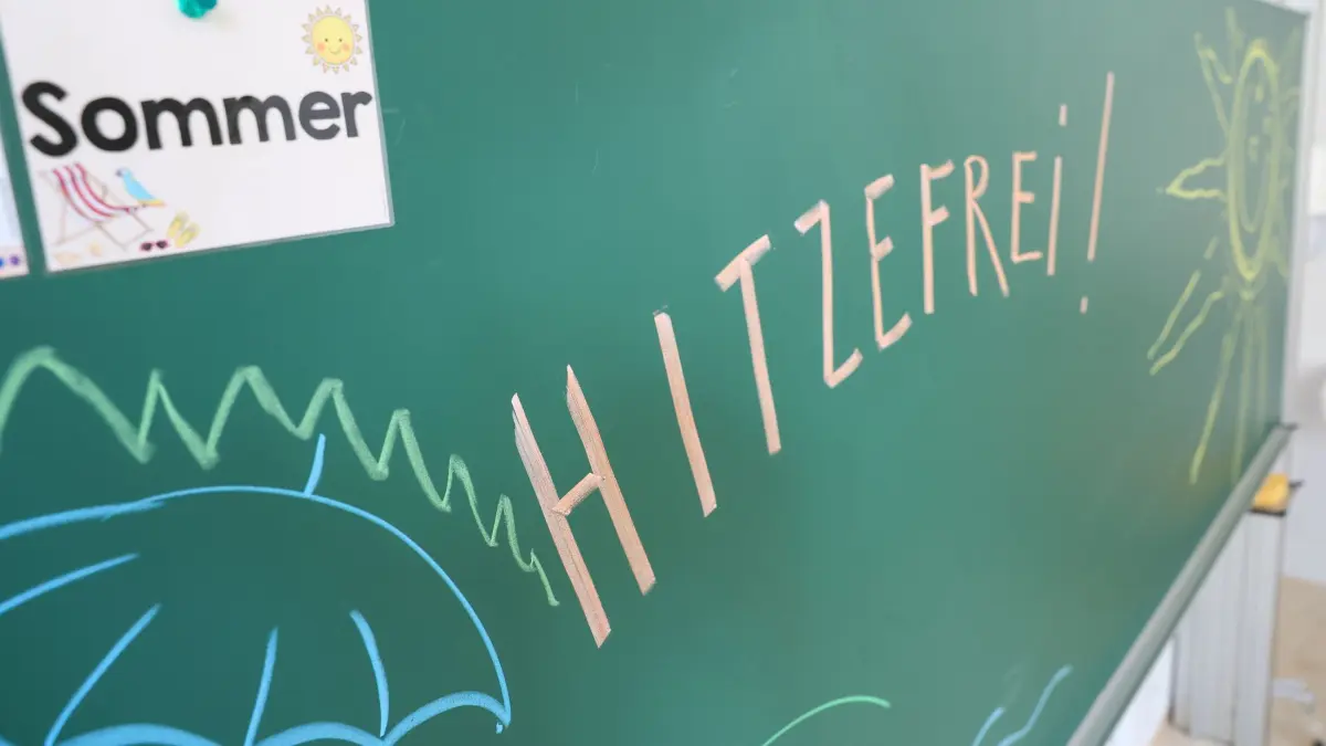 Sommer in Sachsen: ILLUSTRATION - 11.08.2025, Sachsen, Ehrenfriedersdorf: An der Tafel einer Grundschule steht „Hitzefrei!“(gestellte Szene). In Sachsen werden in dieser Woche Temperaturen um die 30 Grad und darüber erwartet. Anders als in anderen Bundesländern gibt es jedoch keine einheitlichen Regeln für "hitzefrei". Die jeweiligen Schulleitungen vor Ort entscheiden, ob eine Fortsetzung des Unterrichts für die Schüler zumutbar ist. Neben "hitzefrei" besteht auch die Möglichkeit, den Unterricht zu verkürzen oder die Pausen zu verlängern. Möglich ist auch der Unterricht im Freien oder Projektunterricht außerhalb der Schule – zum Beispiel im Wald oder im Schwimmbad. Foto: Jan Woitas/dpa +++ dpa-Bildfunk +++