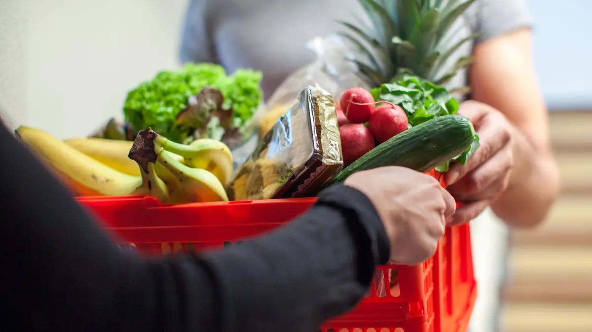 Mann liefert Lebensmittel aus: ILLUSTRATION - Anders als im Supermarkt müssten Online-Händler weder das Mindesthaltbarkeits- noch das Verbrauchsdatum vor dem Kauf angeben. (zu dpa: «Lebensmittel online kaufen: Wann ein Widerruf möglich ist») Foto: Christin Klose/dpa-tmn - Honorarfrei nur für Bezieher des dpa-Themendienstes +++ dpa-Themendienst +++