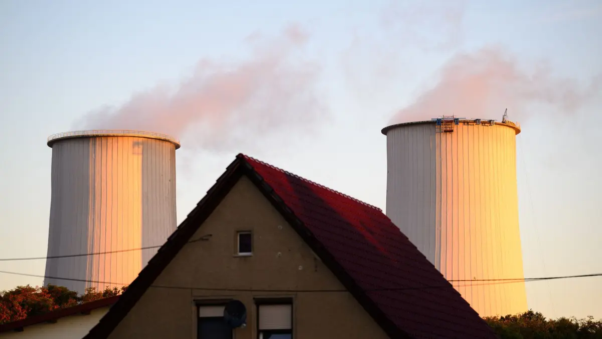 Morgens in Sachsen-Anhalt - Leuna: 03.09.2025, Sachsen-Anhalt, Leuna: Die Schornsteine des Chemieparks Leuna ragen hinter einem Einfamilienhaus empor. Foto: Hendrik Schmidt/dpa +++ dpa-Bildfunk +++