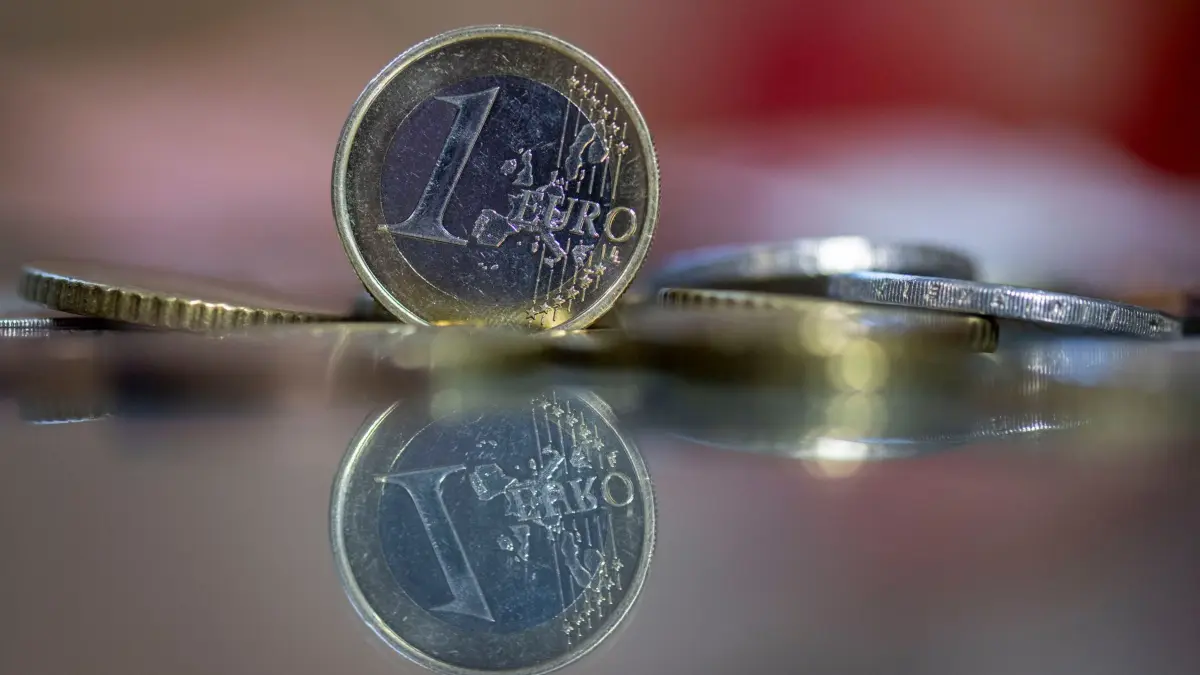 Geldmünzen: ILLUSTRATION - 23.10.2023, Sachsen, Leipzig: Eine 1-Euro-Münze steht auf einem Tisch, umgeben von anderen Euro-Münzen. (zu dpa: «Wieder Krise in Paris: Diese Folgen hat der Regierungssturz») Foto: Hendrik Schmidt/dpa +++ dpa-Bildfunk +++
