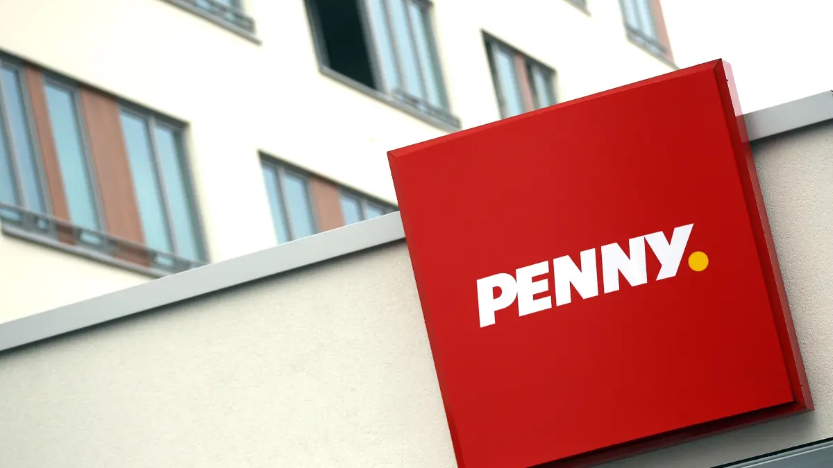 Das neue Logo des Lebensmittel-Discounters "Penny" hängt am Freitag (09.03.2012) in Köln an einem Markt. Der Lebensmitteldiscounter Penny soll mit aufgemöbelten Läden und einem gestrafften Filialnetz wieder profitabel werden. Foto: Oliver Berg dpa/lnw (zu dpa/lnw: "Penny will mit aufgemöbelten Filialen aus den roten Zahlen kommen") ++ +++ dpa-Bildfunk +++
